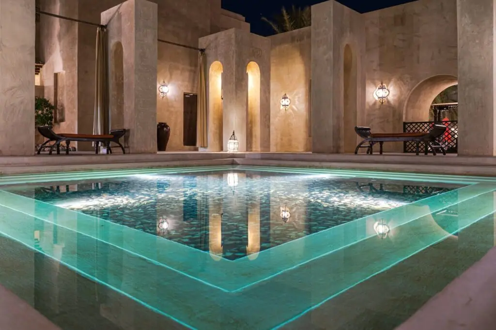 An illuminated luxury swimming pool at night